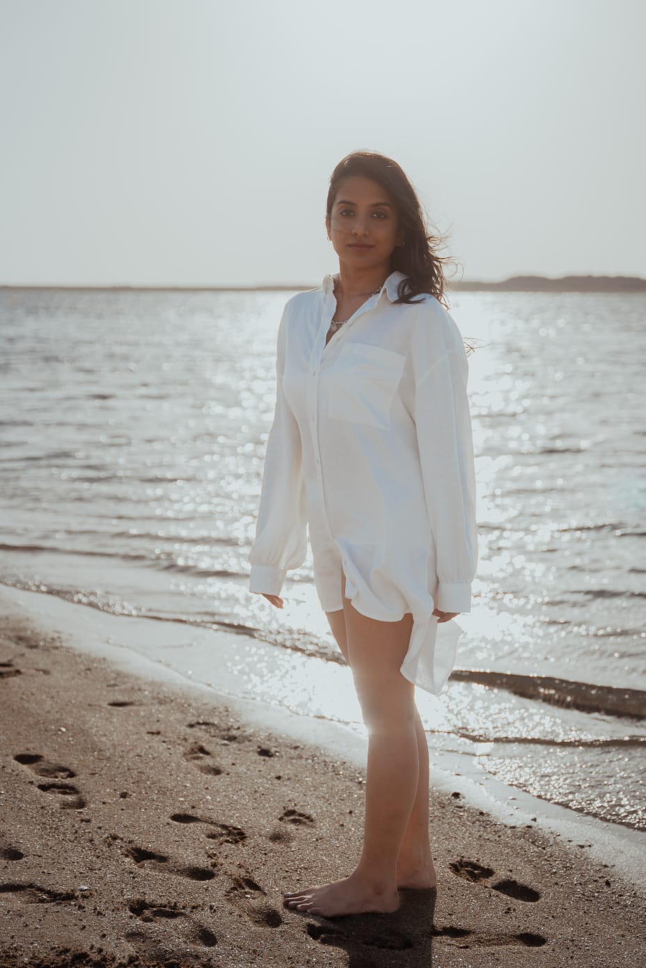 Pooja Venugopal in a white shirt beside the sea